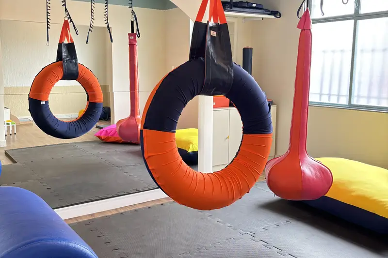Sala de integração sensorial com balanços e pneu suspenso